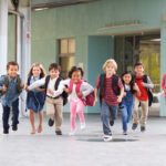 Group of elementary school kids running in a school corridor