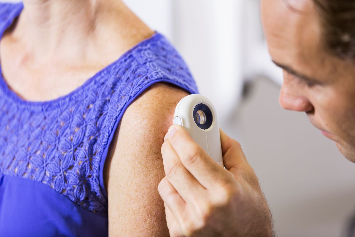 skin-cancer-evaluation Doctor in a clinical setting using an image enhancing device to look directly at a female patients arm