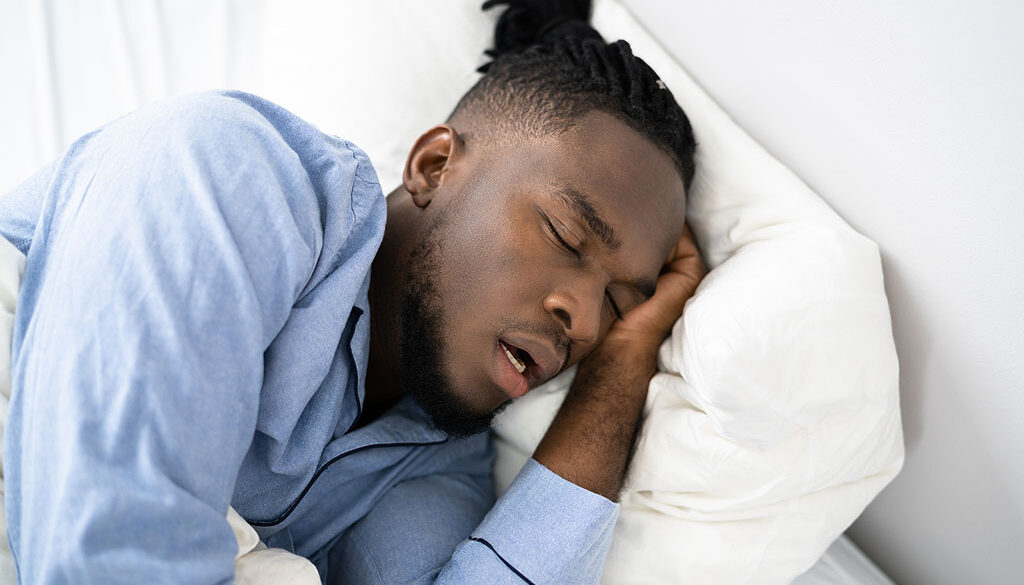 Closeup of an African American Man Sleeping on His Side in Bed With His Mouth Open Mouth Breathing at Night