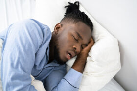 Closeup of an African American Man Sleeping on His Side in Bed With His Mouth Open Mouth Breathing at Night