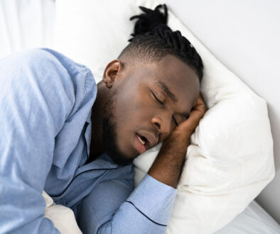 Closeup of an African American Man Sleeping on His Side in Bed With His Mouth Open Mouth Breathing at Night